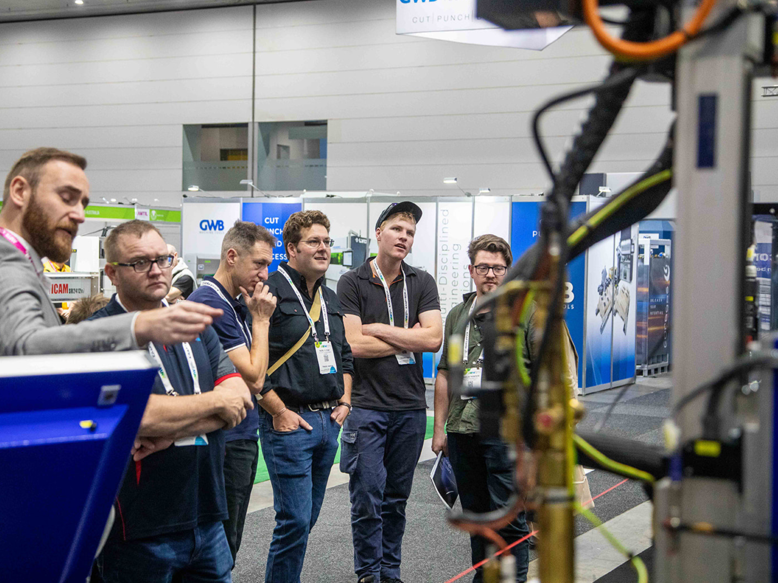 AMW visitors evaluate a piece of equipment on the show floor